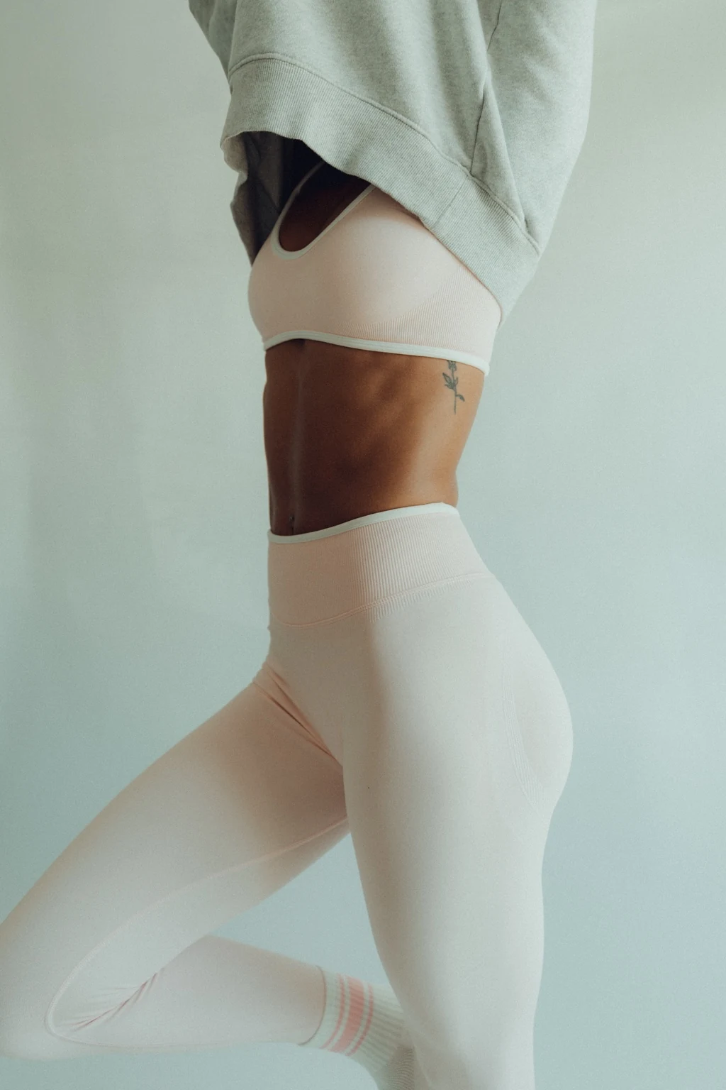 Close Pilates movement portrait in pale activewear