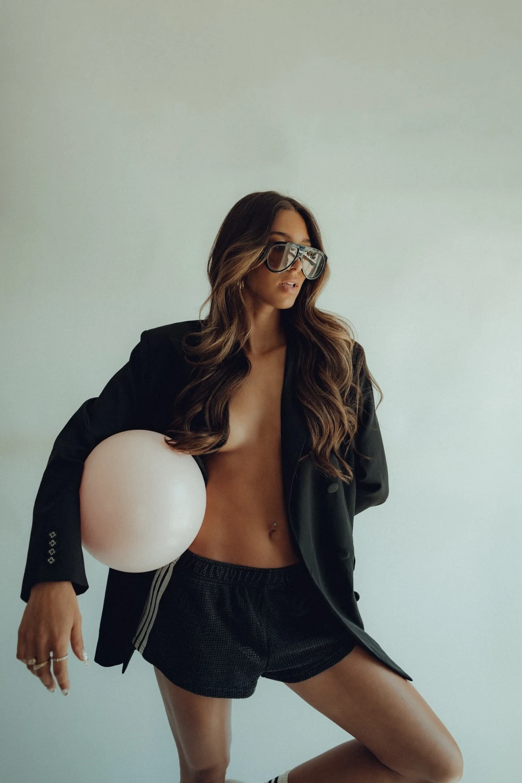Woman in a black blazer holding a pale Pilates ball