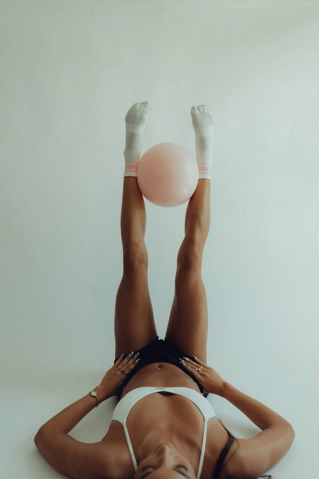 Pilates movement with legs raised and a pale ball